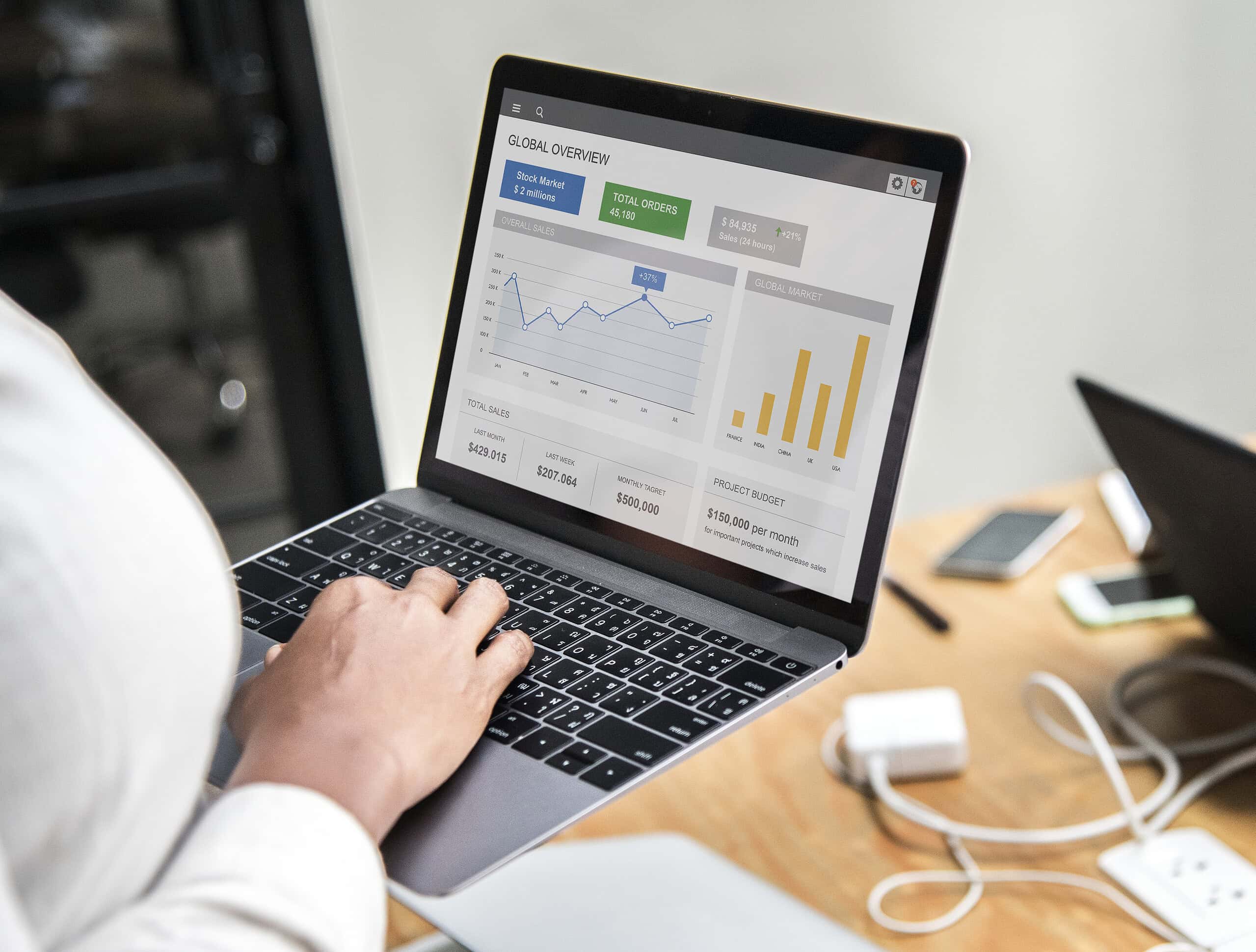 Professional developer analyzing Web Analytics dashboards on a laptop to optimize e-commerce conversion tracking.